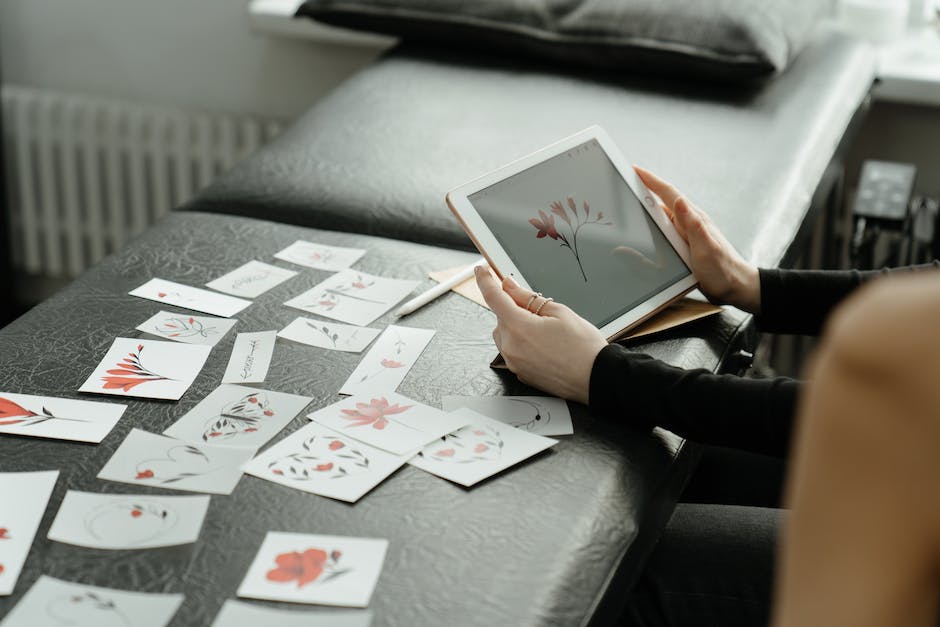 A person sitting at a desk, surrounded by drawings, sketches, and colorful art supplies, representing the role of a creative project manager in managing and implementing creative projects.